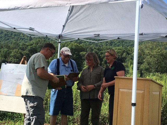 Central Pennsylvania Conservancy executive director Anna Yelk giving appreciation plaques to Flemish Down owners Mike and Annette Blum and to long time Flemish Down land manager Josh First