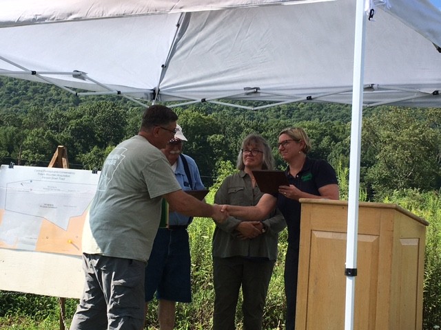 Central Pennsylvania Conservancy executive director Anna Yelk giving appreciation plaques to Flemish Down owners Mike and Annette Blum and to long time Flemish Down land manager Josh First
